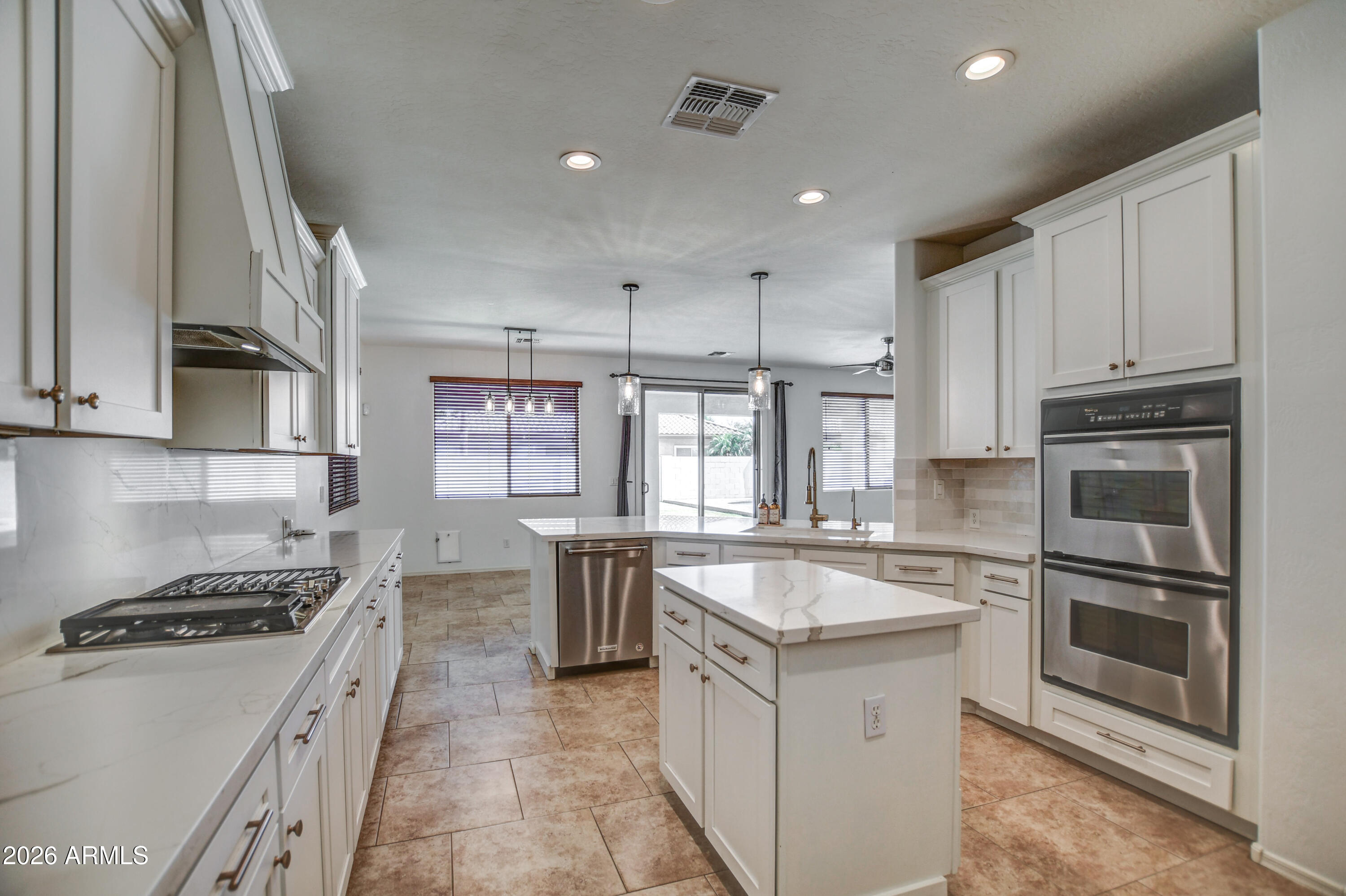 3078 East Muirfield Street Gilbert, AZ 85298 - Photo 39 of 92 a large kitchen with stainless steel appliances granite countertop a stove and a sink
