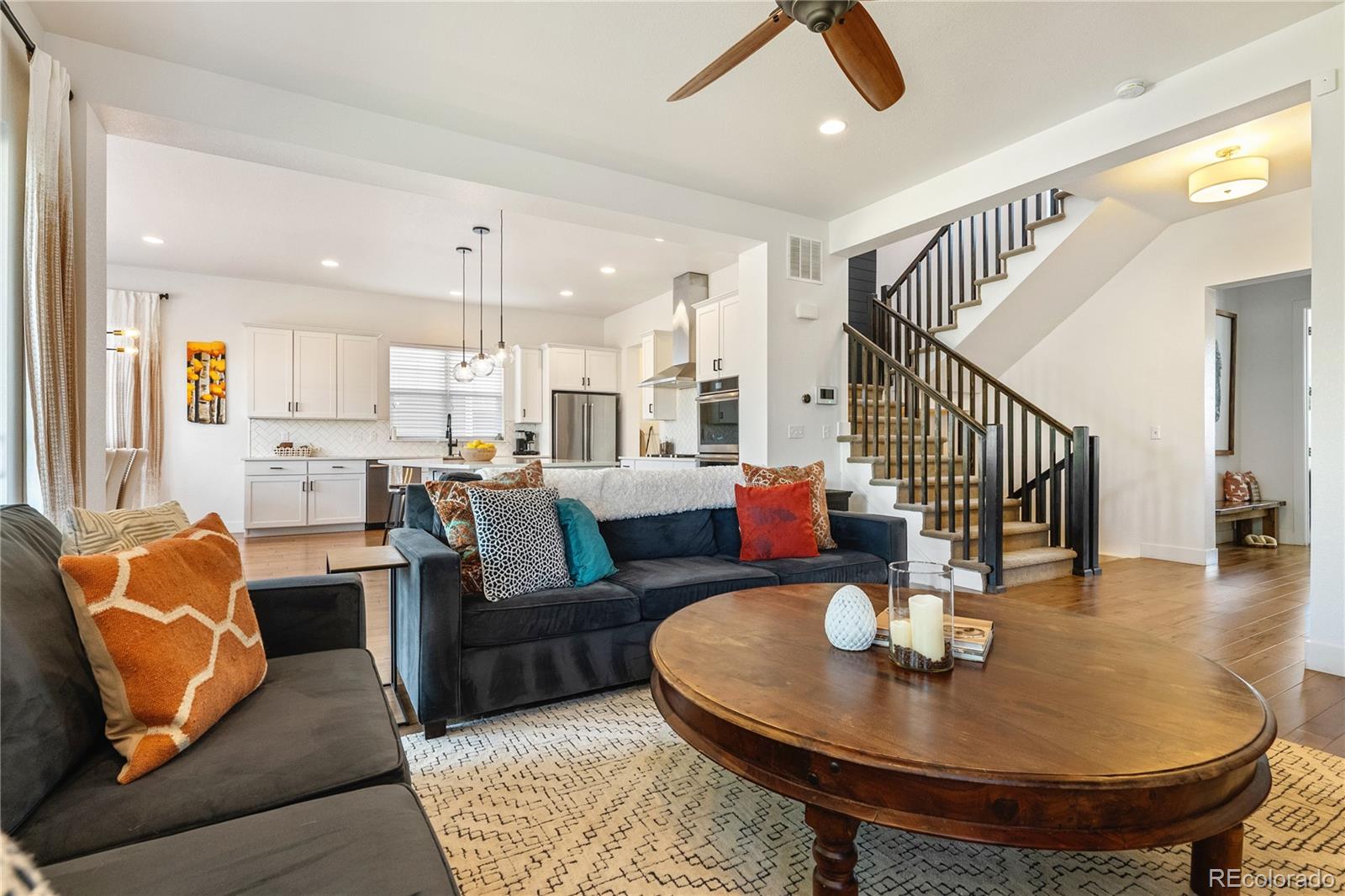 2027 Vallejo Loop Broomfield, CO 80023 - Photo 14 of 50 a living room with couches and a dining table with kitchen view
