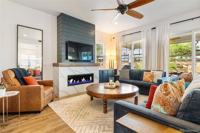 a living room with furniture a fireplace and a large window