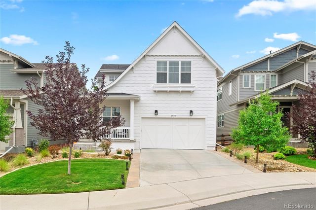 a view of a white house with a yard and plants