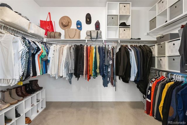 a view of walk in closet with clothes and shoes