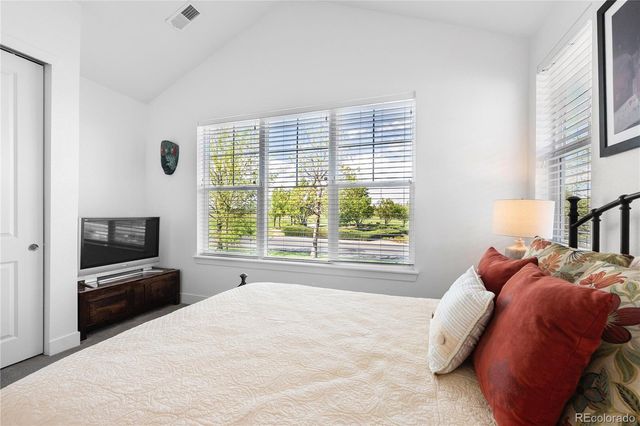 a bed room with a bed television and a window