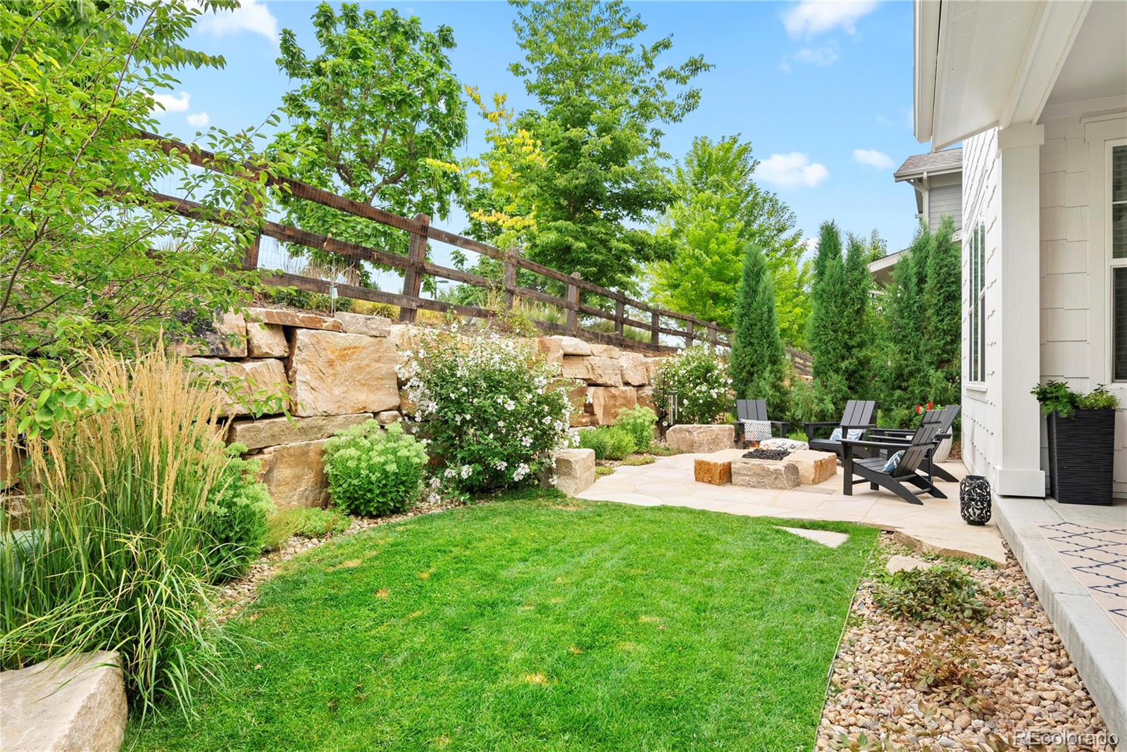 2027 Vallejo Loop Broomfield, CO 80023 - Photo 39 of 50 a backyard of a house with table and chairs plants and large tree