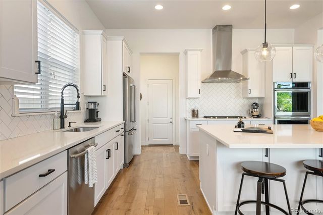 a kitchen with stainless steel appliances a sink stove and refrigerator