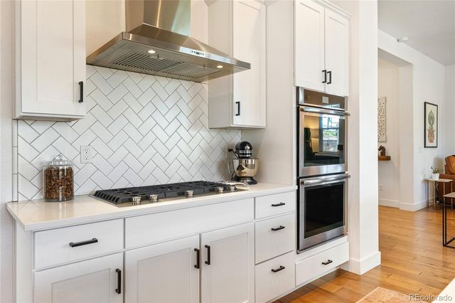 a kitchen with stainless steel appliances white cabinets and a stove