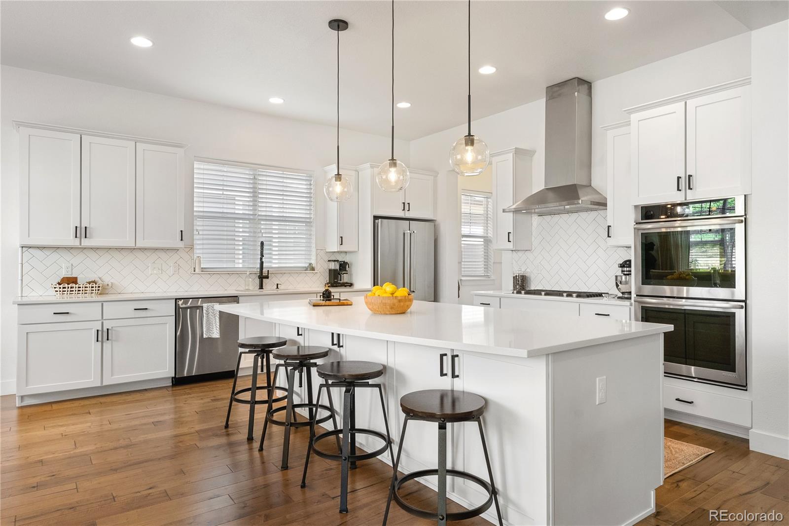 2027 Vallejo Loop Broomfield, CO 80023 - Photo 10 of 50 a kitchen with a refrigerator a stove a dining table and chairs with wooden floor