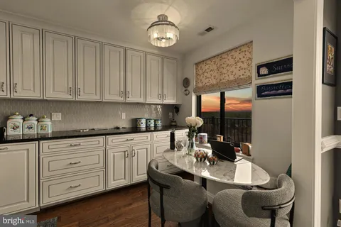 a kitchen with granite countertop a sink cabinets stainless steel appliances and a window