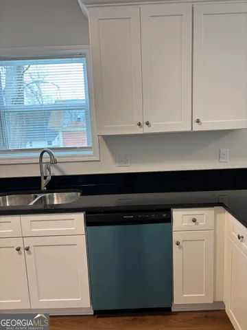 a kitchen with white cabinets and a sink
