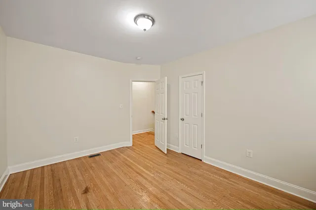 a view of empty room with wooden floor