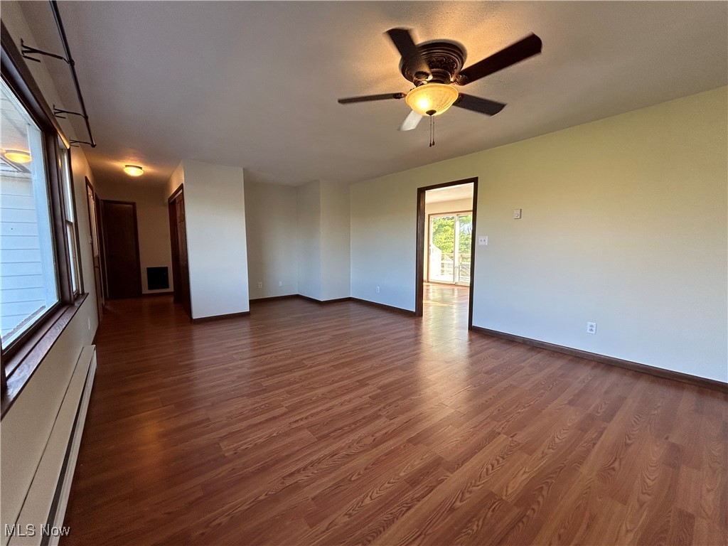 56376 Jordan Run Road Bellaire, OH 43906 - Photo 10 of 45 Spare room with visible vents, baseboards, ceiling fan, dark wood-style floors, and a baseboard heating unit