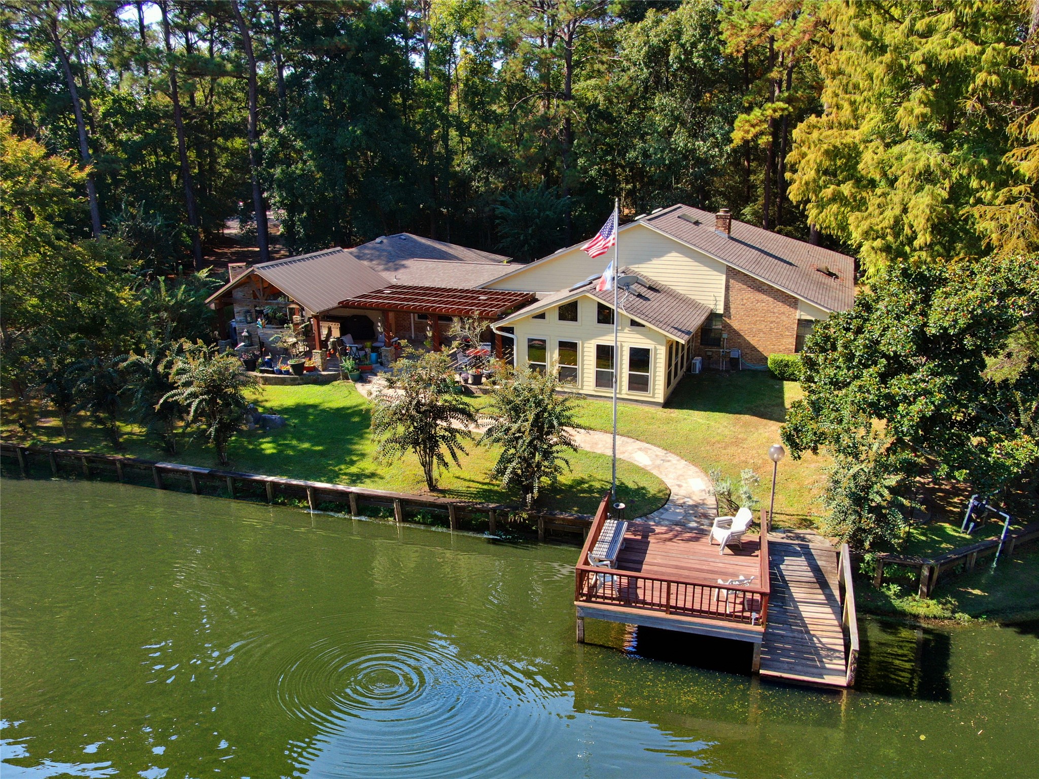 a front view of a house with a garden and swimming pool