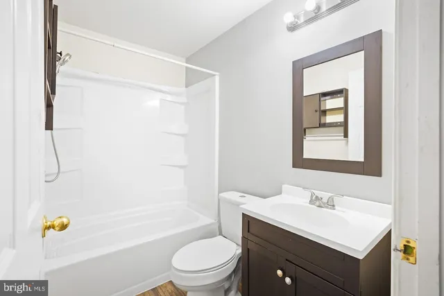 a bathroom with a sink vanity toilet and tub