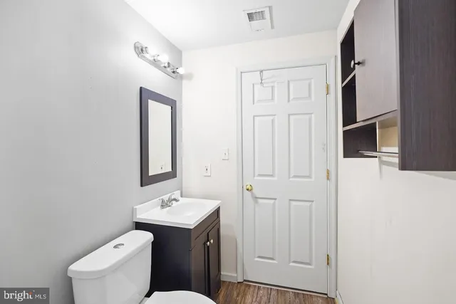 a bathroom with a toilet a sink a mirror a shower and vanity