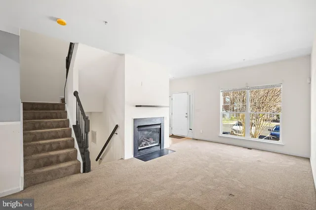 a view of an empty room with a fireplace and a window