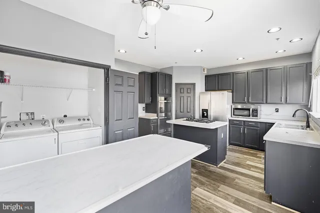 a large kitchen with kitchen island a sink stainless steel appliances and cabinets