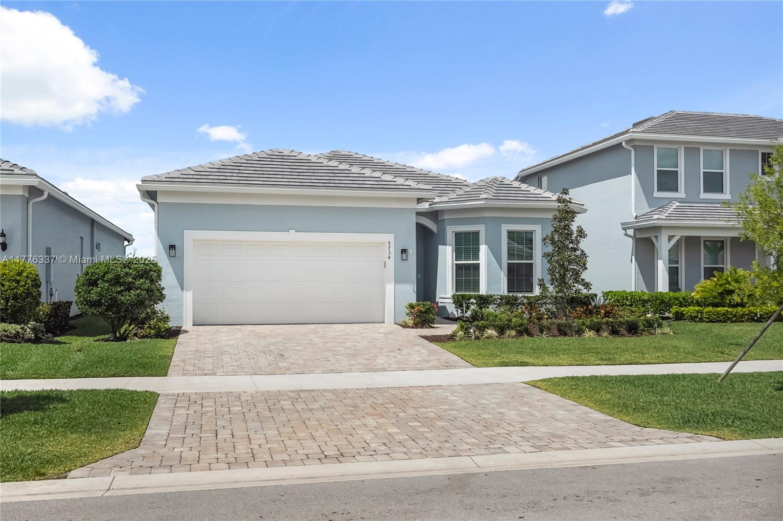 9734 Southwest Meridian Way Stuart, FL 34997 - Photo 2 of 48 a front view of a house with a yard and garage