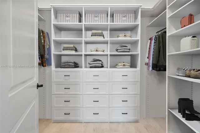 a view of walk in closet with clothes and shoes