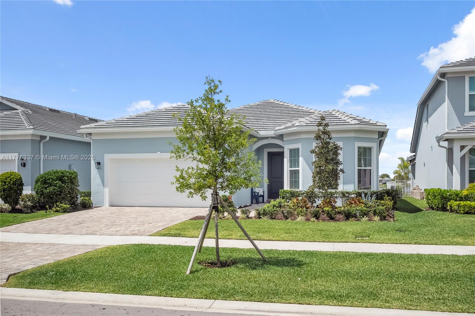 9734 Southwest Meridian Way Stuart, FL 34997 - Photo 3 of 48 a front view of a house with a yard