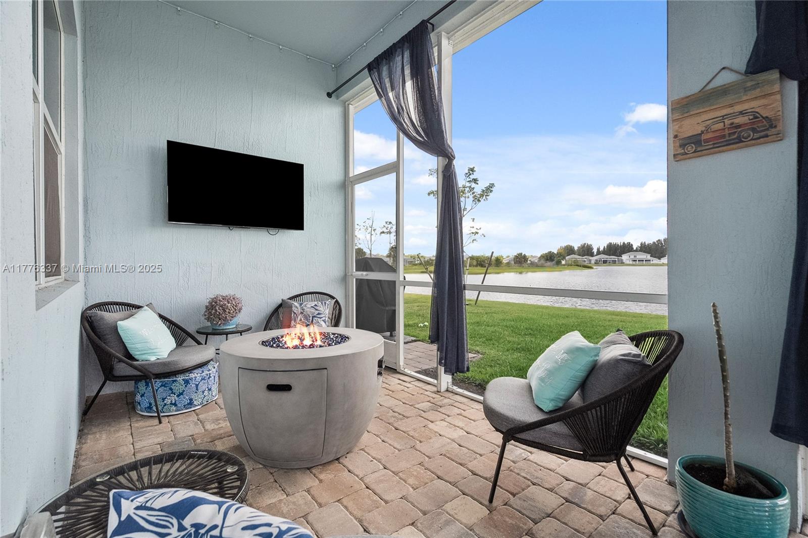 9734 Southwest Meridian Way Stuart, FL 34997 - Photo 36 of 48 a outdoor living room with furniture a flat screen tv and a floor to ceiling window