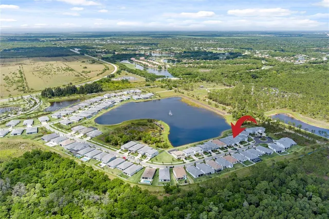 an aerial view of a house with a garden and lake view