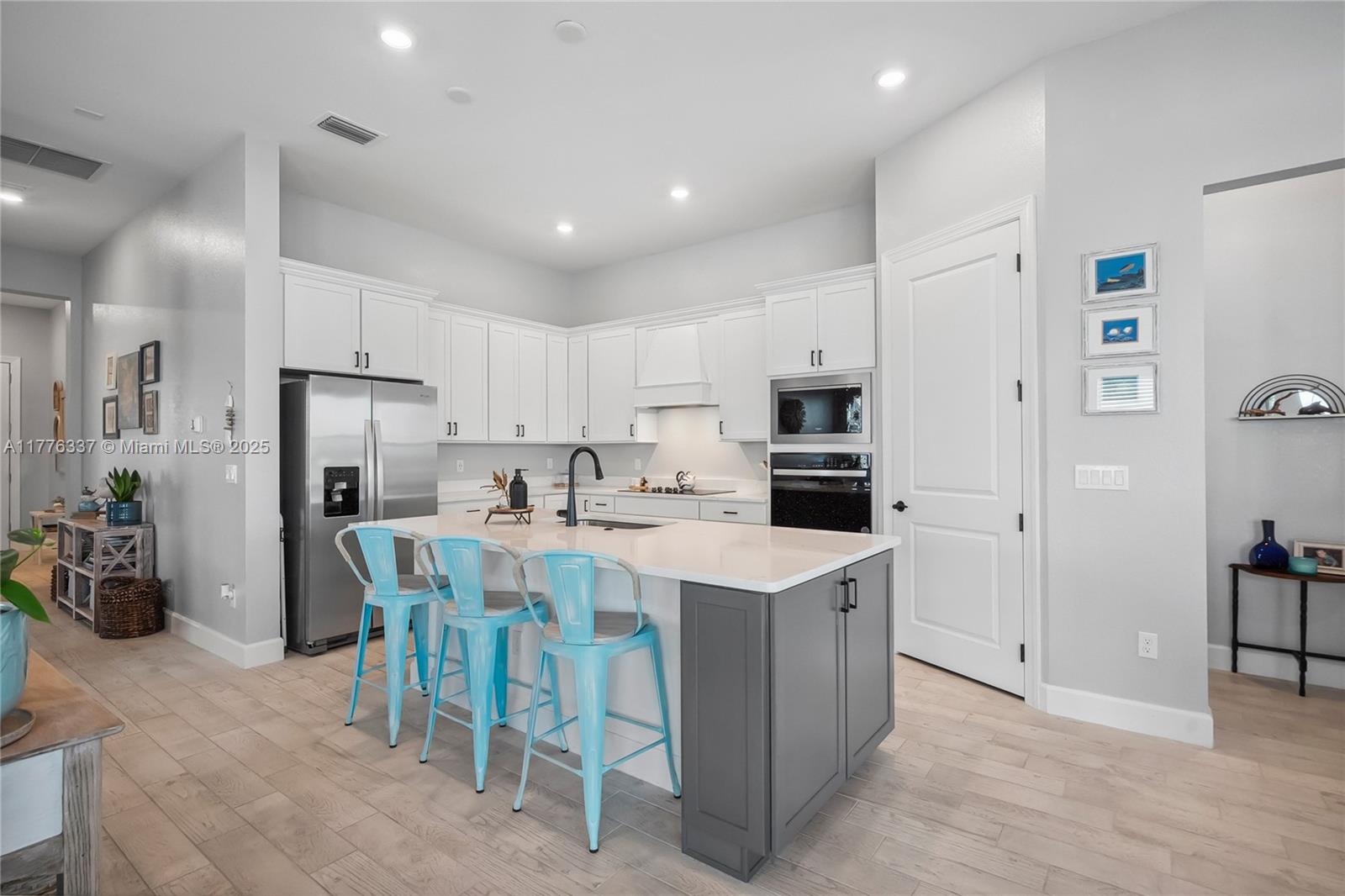 9734 Southwest Meridian Way Stuart, FL 34997 - Photo 7 of 48 a kitchen that has a lot of white cabinets and stainless steel appliances