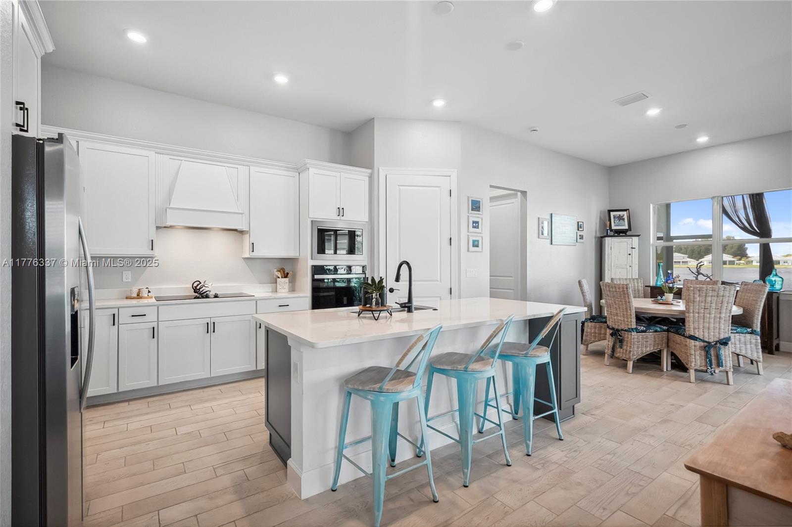 9734 Southwest Meridian Way Stuart, FL 34997 - Photo 8 of 48 a kitchen with appliances a sink a counter top space and living room view