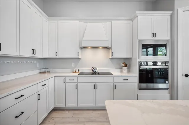 a kitchen with cabinets appliances a sink and a counter space