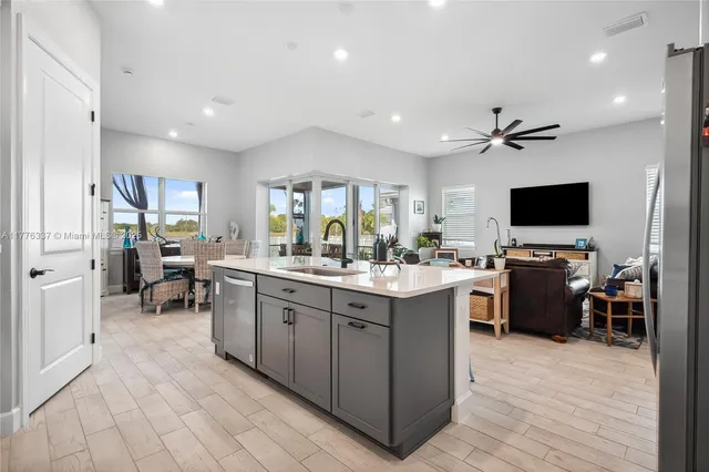 a large kitchen with kitchen island a sink a counter space and stainless steel appliances