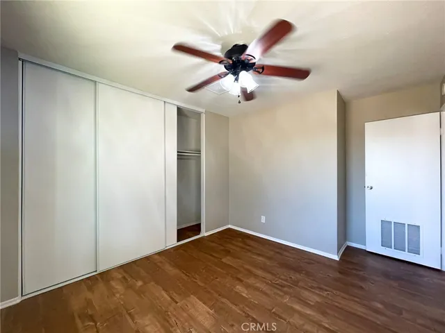 a view of a room with wooden floor and a ceiling fan
