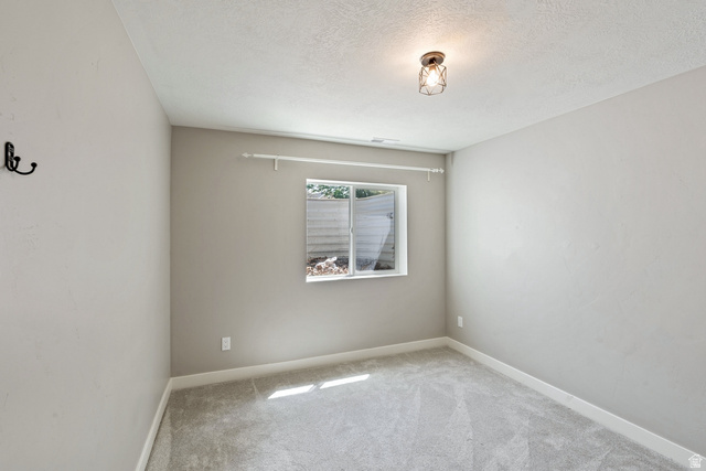 444 South Saddle Road Grantsville, UT 84029 - Photo 17 of 33 Unfurnished room with carpet flooring and a textured ceiling