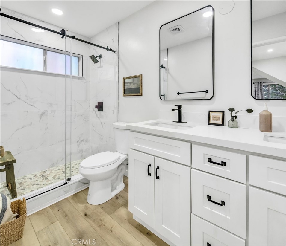 377 Hillside Road Lake Arrowhead, CA 92352 - Photo 14 of 33 a bathroom with a toilet sink double vanity and shower