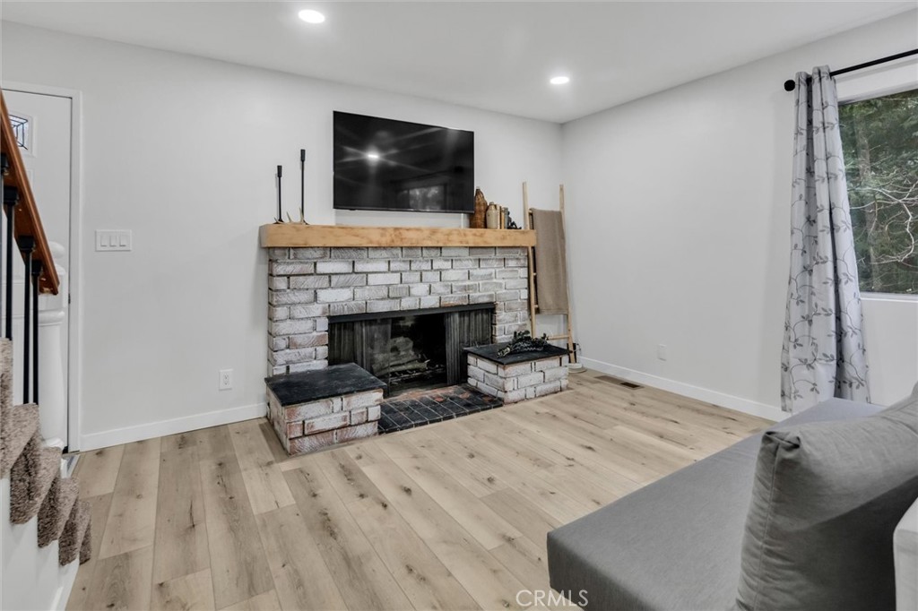 377 Hillside Road Lake Arrowhead, CA 92352 - Photo 3 of 33 a living room with furniture and a fireplace