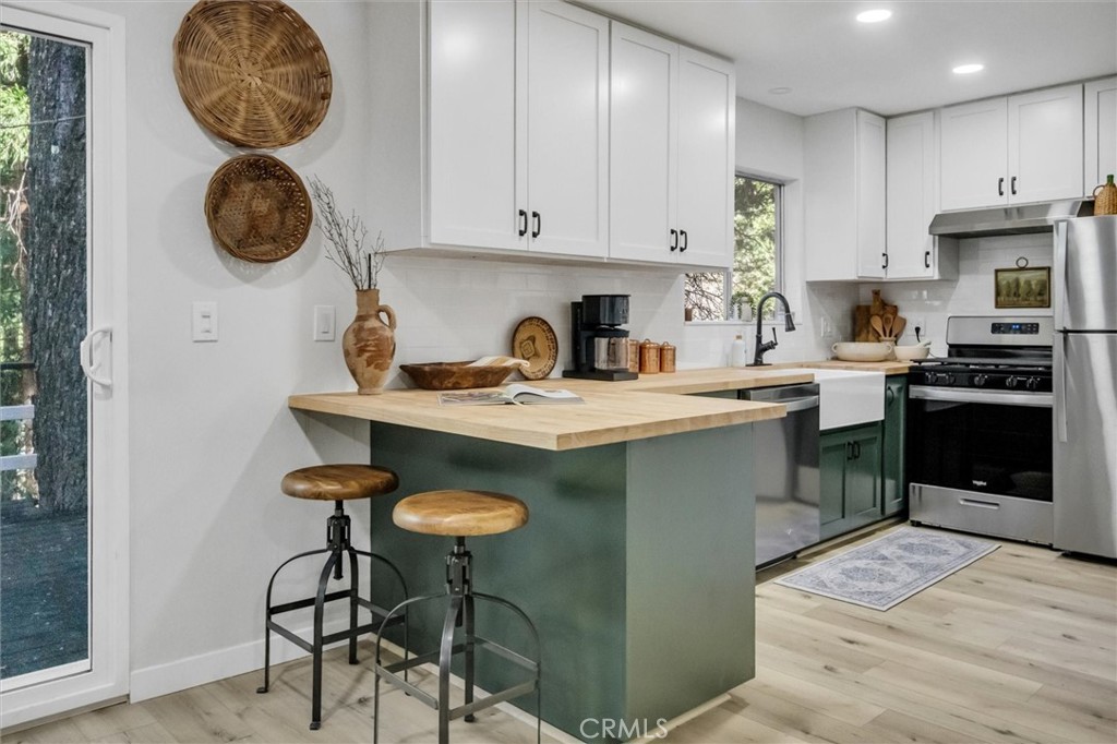 377 Hillside Road Lake Arrowhead, CA 92352 - Photo 7 of 33 a kitchen with stainless steel appliances granite countertop a stove a sink and a refrigerator