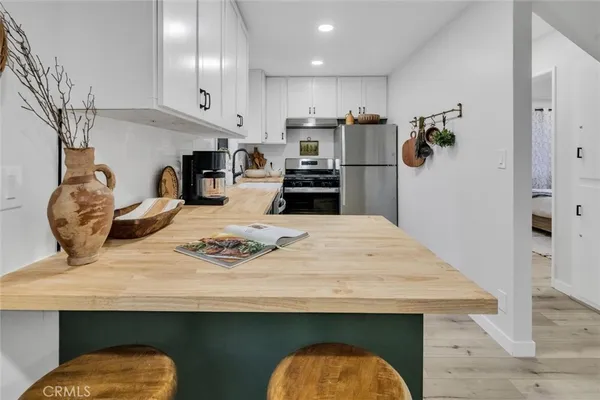 a kitchen with white cabinets and black appliances