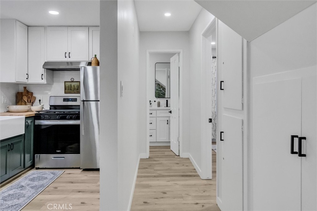 377 Hillside Road Lake Arrowhead, CA 92352 - Photo 10 of 33 a kitchen with white cabinets and black appliances