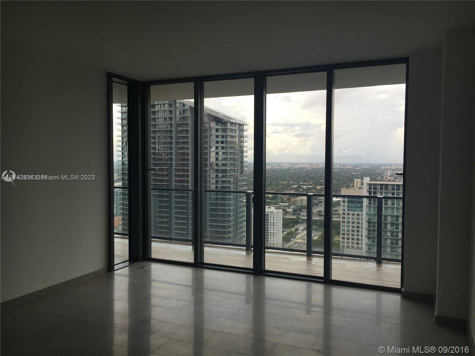 68 Southeast 6th Street, Unit 3510 Miami, FL 33131 - Photo 15 of 19 a view of an empty room with wooden floor and walls