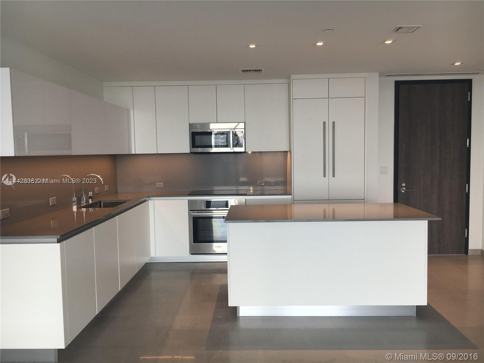 68 Southeast 6th Street, Unit 3510 Miami, FL 33131 - Photo 17 of 19 a large kitchen with stainless steel appliances a large counter top and a stove