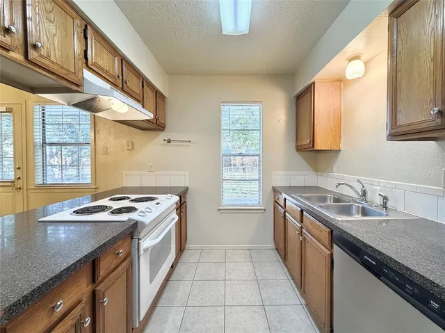 a kitchen with stainless steel appliances granite countertop a sink stove and cabinets