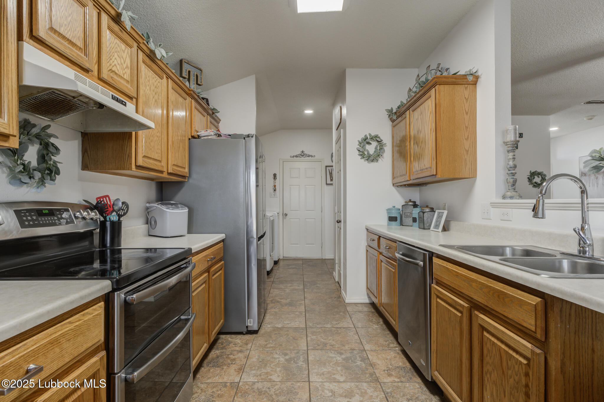 6223 18th Street Lubbock, TX 79416 - Photo 11 of 29 a kitchen with stainless steel appliances granite countertop a sink stove and refrigerator