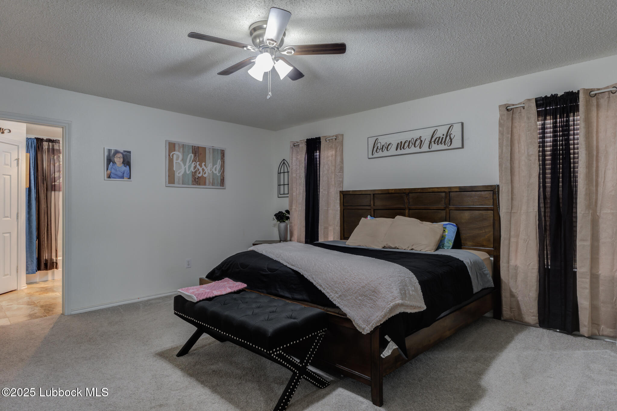 6223 18th Street Lubbock, TX 79416 - Photo 16 of 29 a spacious bedroom with a bed and a chandelier