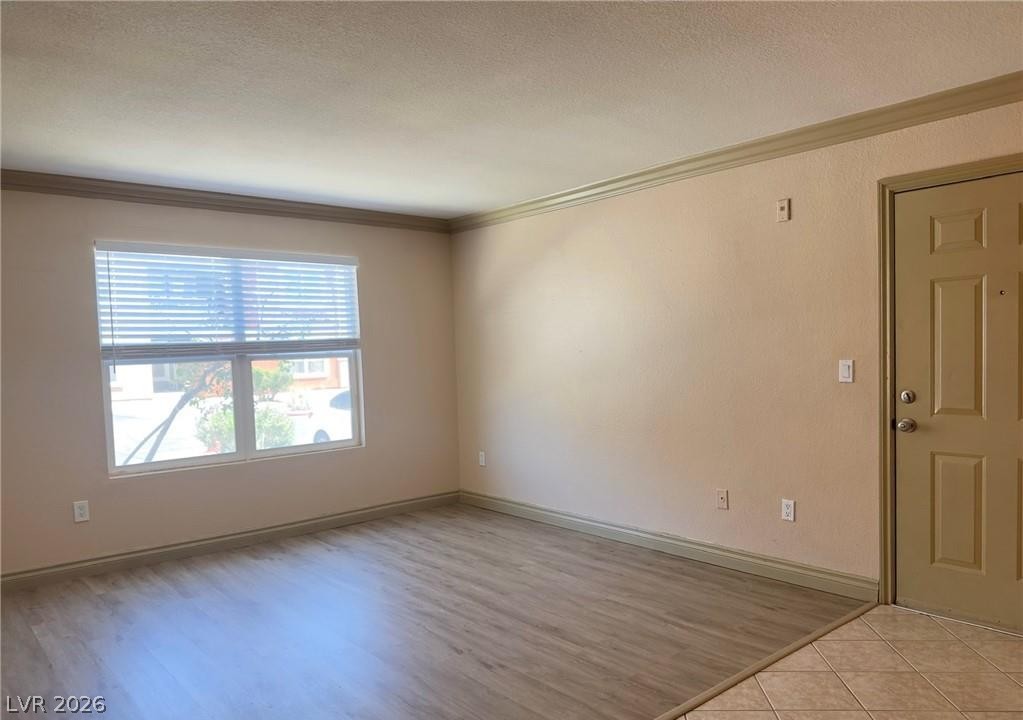 8101 West Flamingo Road, Unit 1082 Las Vegas, NV 89147 - Photo 7 of 23 A well-lit living area features laminate flooring and a functional entry.