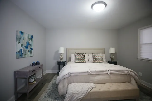 a bedroom with a bed and a painting on the wall