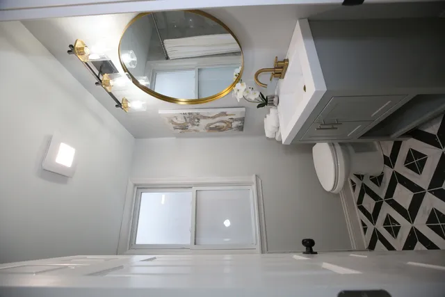 a view of a livingroom with wooden floor and a mirror