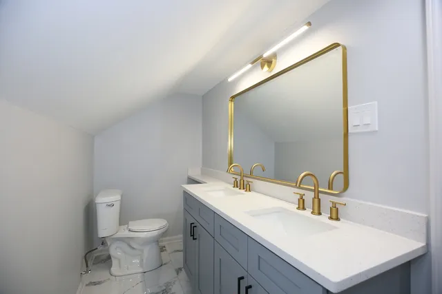 a bathroom with a sink toilet and mirror