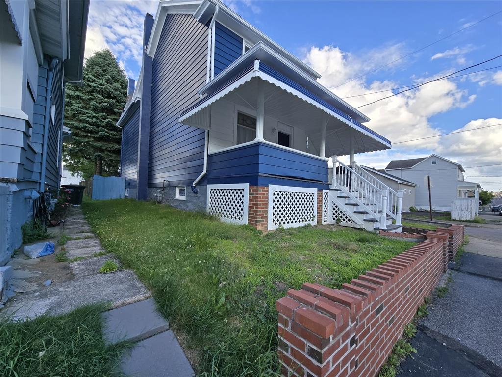 883 North Locust Street Hazleton, PA 18201 - Photo 5 of 83 A classic blue siding residence with a welcoming front porch, poised within a residential street setting.