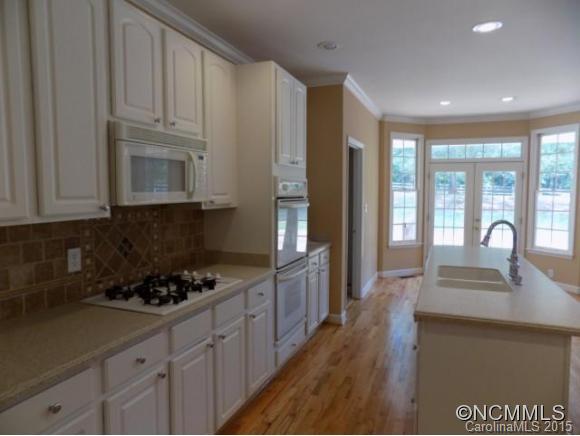 418 Chisholm Trail Rutherfordton, NC 28139 - Photo 6 of 22 a kitchen with granite countertop a stove a sink dishwasher and cabinets with wooden floor