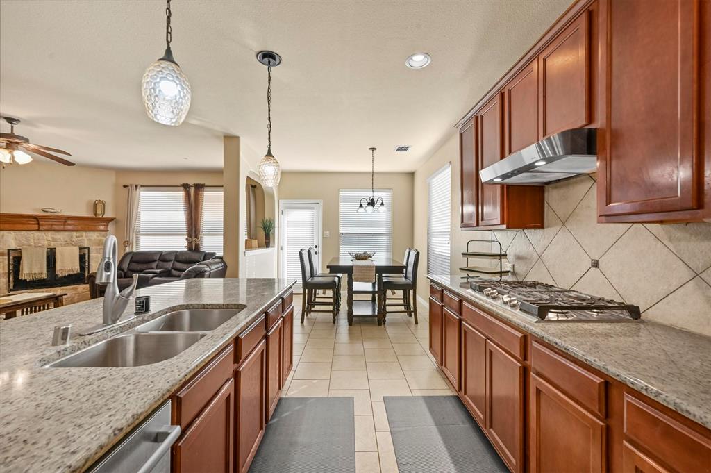 14815 Frisco Ranch Drive Little Elm, TX 75068 - Photo 9 of 40 a kitchen with stainless steel appliances granite countertop a sink a stove and a wooden floors