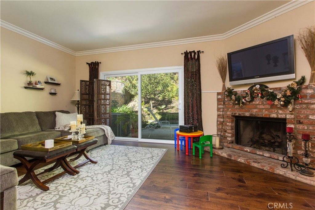 30311 Goodspring Drive Agoura Hills, CA 91301 - Photo 9 of 18 a living room with furniture a flat screen tv and a fireplace