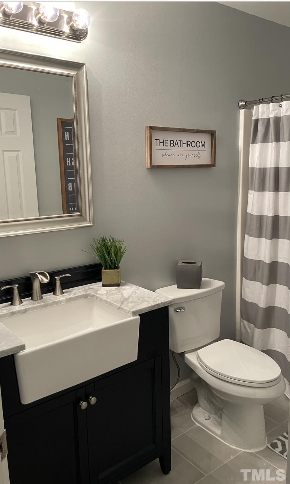 1206 Maroon Drive Durham, NC 27713 - Photo 5 of 11 a bathroom with a sink a toilet and mirror