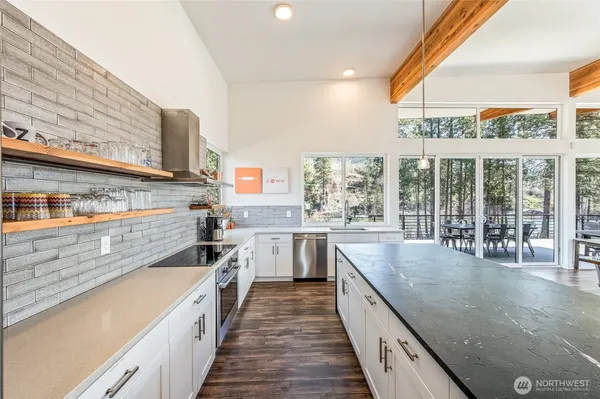 a kitchen with stainless steel appliances granite countertop sink stove and large window